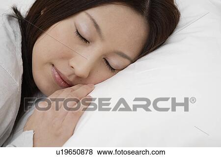 Stock Photo - A young woman sleeping peacefully. Fotosearch