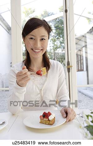 Portrait of a cheerful woman eating pastry View Large Photo Image Stock Photo - Portrait of a cheerful woman eating pastry. Fotosearch