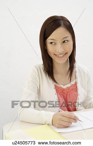 Stock Image - View of a cheerful woman holding a pen. Fotosearch