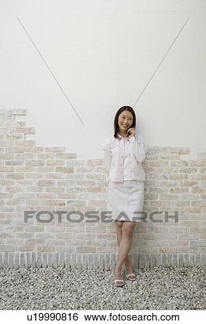 Stock Photograph - View of a woman using cellphone. Fotosearch