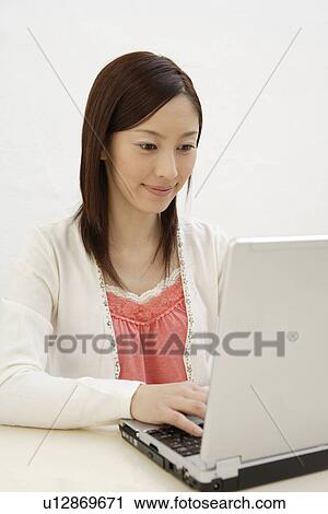Stock Image - View of a young woman using laptop. Fotosearch