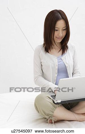Stock Photo - View of a young woman using laptop. Fotosearch