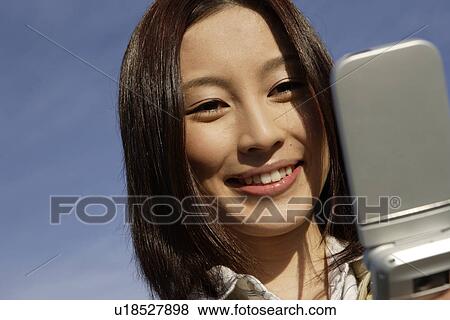 Close-up of a young woman using cellphone View Large Photo Image Stock Photo - Close-up of a young woman using cellphone. Fotosearch