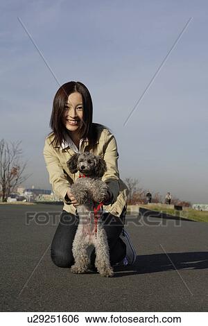 Stock Photograph - Portrait of a young woman with her pet dog. Fotosearch