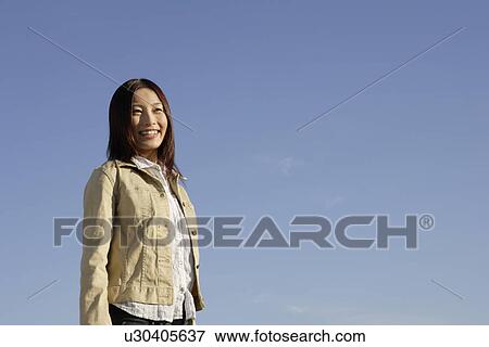 Side view of a cheerful young woman View Large Photo Image Stock Photo - Side view of a cheerful young woman. Fotosearch