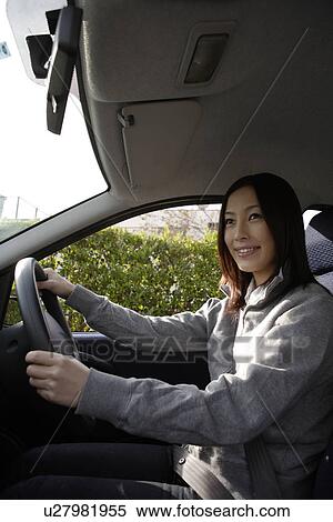 Stock Photography - View of a woman sitting in a car. Fotosearch
