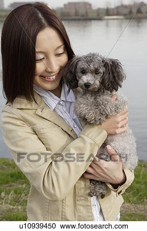 View of a young woman holding pet dog View Large Photo Image Stock Image - View of a young woman holding pet dog. Fotosearch