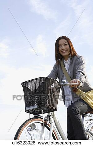 Stock Photograph - View of a young woman on a bicycle. Fotosearch