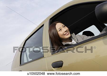 View of a young woman sitting in a car View Large Photo Image Stock Photo - View of a young woman sitting in a car. Fotosearch