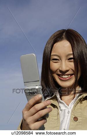 Picture - View of a young woman using cellphone. Fotosearch