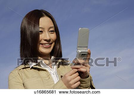 View of a young woman using cellphone View Large Photo Image Stock Image - View of a young woman using cellphone. Fotosearch