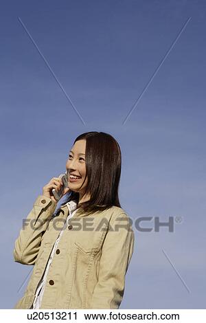 Stock Image - View of a young woman using cellphone. Fotosearch