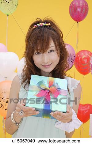 Portrait of a teenage girl holding a gift box View Large Photo Image Stock Photo - Portrait of a teenage girl holding a gift box. Fotosearch
