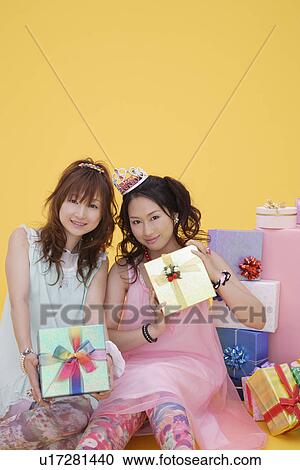 Stock Image - Portrait of teenage girls with gift boxes. Fotosearch