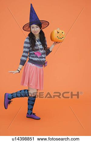View of a teenage girl holding jack-o-lantern View Large Photo Image Stock Image - View of a teenage girl holding jack-o-lantern. Fotosearch