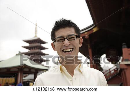 A young man standing outside temple View Large Photo Image Stock Photo - A young man standing outside temple. Fotosearch