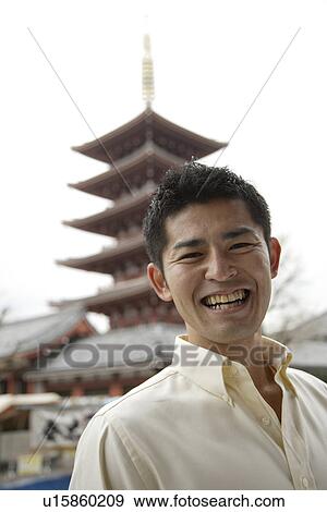 A young man standing outside temple View Large Photo Image Stock Photo - A young man standing outside temple. Fotosearch