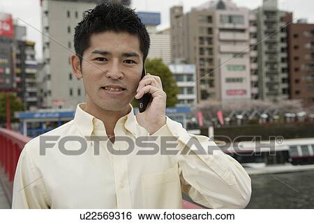 Stock Photograph - A young man using cellphone. Fotosearch