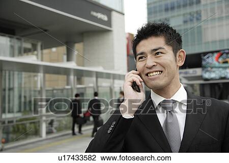Stock Image - Close-up of a businessman using mobile phone. Fotosearch