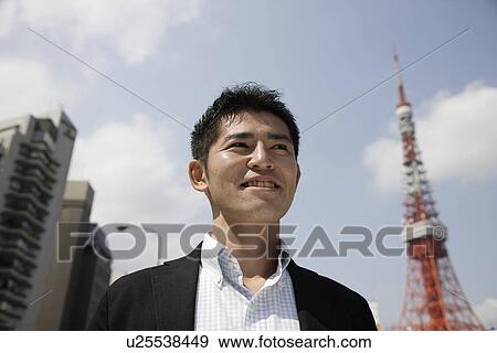 Stock Photo - Low angle view of a man looking away. Fotosearch
