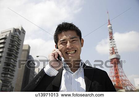 Low angle view of a man using mobile phone View Large Photo Image Stock Image - Low angle view of a man using mobile phone. Fotosearch