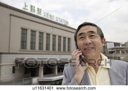 Stock Image - Close-up of a senior man using mobile phone. Fotosearch