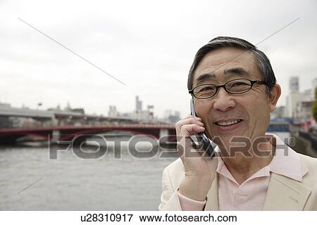 Portrait of a smiling senior man using mobile phone View Large Photo Image Stock Photo - Portrait of a smiling senior man using mobile phone. Fotosearch