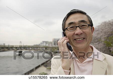 Portrait of a smiling senior man using mobile phone View Large Photo Image Stock Photography - Portrait of a smiling senior man using mobile phone. Fotosearch
