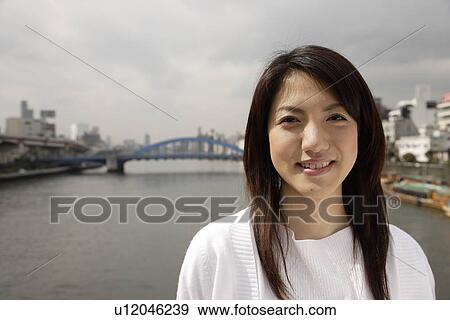 Close-up of a young woman smiling View Large Photo Image Stock Photo - Close-up of a young woman smiling. Fotosearch