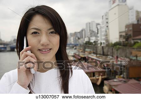 Close-up of a young woman using mobile phone View Large Photo Image Stock Photo - Close-up of a young woman using mobile phone. Fotosearch