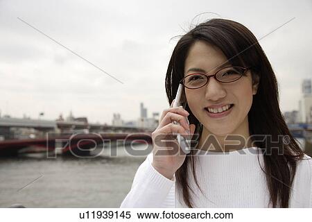 Close-up of a young woman using mobile phone View Large Photo Image Stock Photography - Close-up of a young woman using mobile phone. Fotosearch