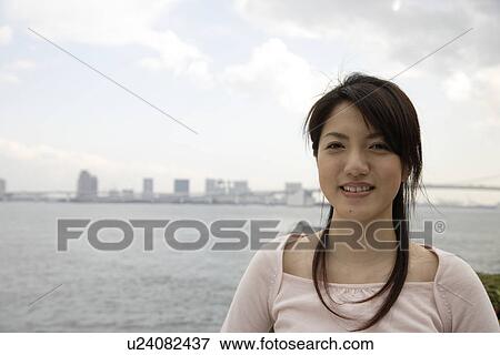 Portrait of a smiling young woman View Large Photo Image Stock Photo - Portrait of a smiling young woman. Fotosearch