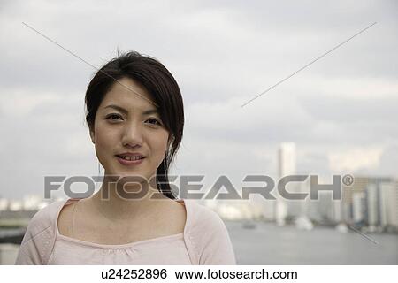 Portrait of a smiling young woman View Large Photo Image Stock Photograph - Portrait of a smiling young woman. Fotosearch