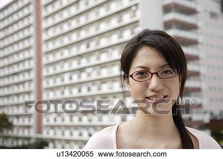 Stock Photography - Portrait of a smiling young woman wearing glasses. Fotosearch
