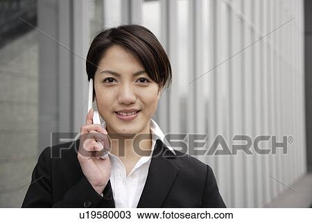 Portrait of a smiling young woman using mobile phone View Large Photo Image Stock Image - Portrait of a smiling young woman using mobile phone. Fotosearch