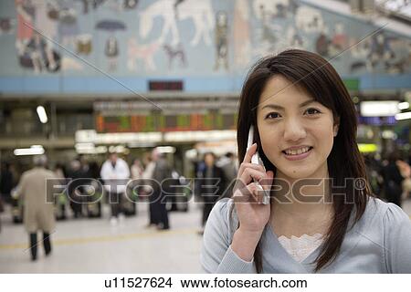 Portrait of a young woman using mobile phone View Large Photo Image Picture - Portrait of a young woman using mobile phone. Fotosearch