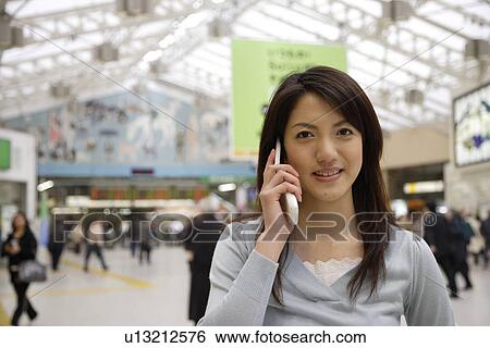 Portrait of a young woman using mobile phone at the station View Large Photo Image Stock Photograph - Portrait of a young woman using mobile phone at the station. Fotosearch