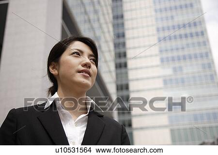 Picture - View of a young woman standing near the building. Fotosearch