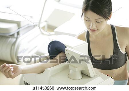 A young woman checks her pulse rate and blood pressure on the digital indicator View Large Photo Image Stock Photo - A young woman checks her pulse rate and blood pressure on the digital indicator. Fotosearch