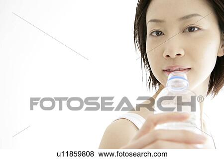 Front view of a young woman drinking water after her exercise View Large Photo Image Stock Photo - Front view of a young woman drinking water after her exercise. Fotosearch