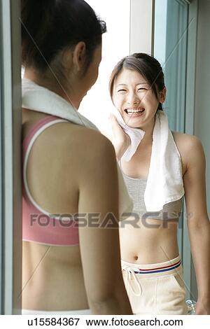 Stock Photo - Two young women share a laughter moment after their exercise. Fotosearch