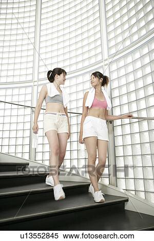 Stock Photography - Two young women walk down the stairs after their exercise. Fotosearch