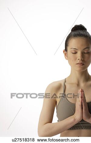 Stock Photo - Close-up of a young woman meditating. Fotosearch