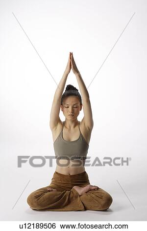 Front view of a young woman meditating in lotus position View Large Photo Image Stock Photograph - Front view of a young woman meditating in lotus position. Fotosearch