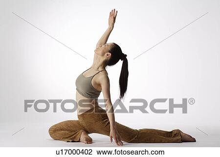 Stock Image - View of a young woman stretching her body. Fotosearch