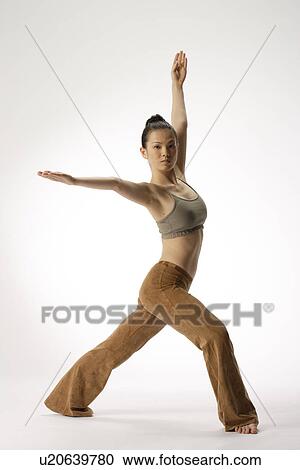 Stock Image - View of a young woman stretching her body. Fotosearch