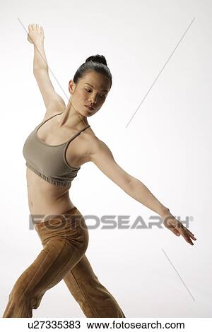 Stock Image - View of a young woman stretching her body. Fotosearch
