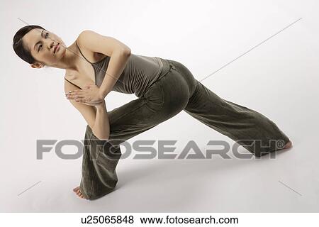 Stock Photo - View of a young woman stretching her body. Fotosearch