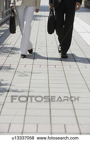 Cropped of two professionals walking View Large Photo Image Stock Photo - Cropped of two professionals walking. Fotosearch