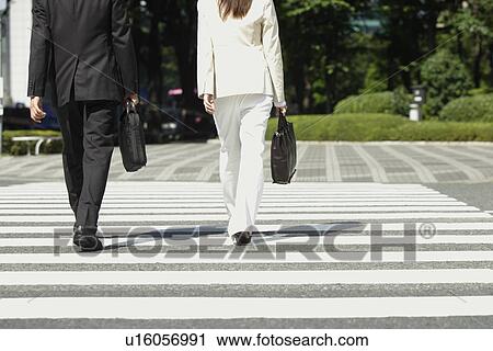 Cropped view of two people walking on crosswalk View Large Photo Image Stock Image - Cropped view of two people walking on crosswalk. Fotosearch